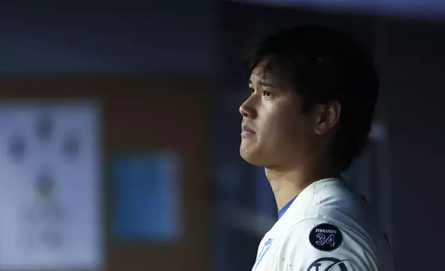 Los Angeles Dodgers' Shohei Ohtani looks on in the dugout during the fifth inning of a baseball game against the Toronto Blue Jays, Saturday, Aug. 9, 2025, in Los Angeles. (AP Photo/Jessie Alcheh)