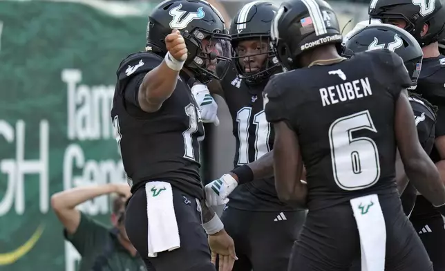 South Florida quarterback Byrum Brown (17) celebrates his touchdown against Boise State with wide receiver Keshaun Singleton (11) and wide receiver Mudia Reuben (6) during the first half of an NCAA college football game Thursday, Aug. 28, 2025, in Tampa, Fla. (AP Photo/Chris O'Meara)