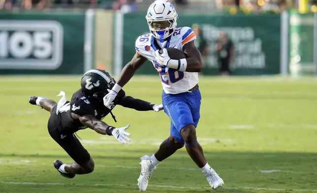 Boise State running back Sire Gaines (26) breaks free from South Florida defensive back Kajuan Banks (13) during the first half of an NCAA college football game Thursday, Aug. 28, 2025, in Tampa, Fla. (AP Photo/Chris O'Meara)