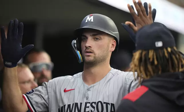 Minnesota Twins' Matt Wallner celebrates in the dugout after hitting a solo home run during the sixth inning of a baseball game against the Detroit Tigers, Monday, Aug. 4, 2025, in Detroit. (AP Photo/Ryan Sun)