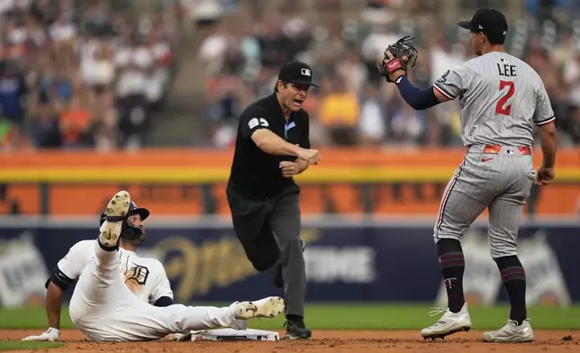 Detroit Tigers designated hitter Riley Greene, left, is called out at second base by umpire Ben May, center, as Minnesota Twins shortstop Brooks Lee (2) watches during the sixth inning of a baseball game, Monday, Aug. 4, 2025, in Detroit. (AP Photo/Ryan Sun)