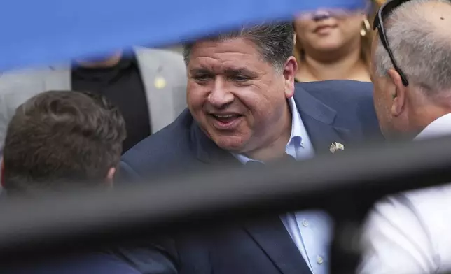 Illinois Governor JB Pritzker greets people as he walks to a news conference in a Chicago water taxi Monday, Aug. 25, 2025, in Chicago. (AP Photo/Nam Y. Huh)