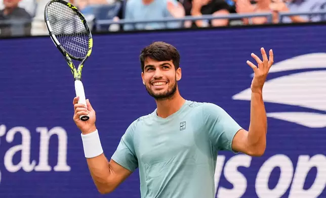 Carlos Alcaraz, of Spain, gestures to fans during a mixed doubles match at the U.S. Open tennis championships, Tuesday, Aug. 19, 2025, in New York. (AP Photo/Yuki Iwamura)