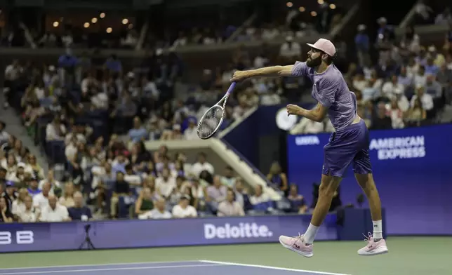 Reilly Opelka, of the United States, serves to Carlos Alcaraz, of Spain, during the first round of the U.S. Open tennis championships, Monday, Aug. 25, 2025, in New York. (AP Photo/Adam Hunger)