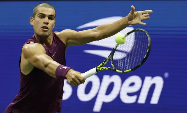Carlos Alcaraz, of Spain, returns a shot to Reilly Opelka, of the United States, during the first round of the U.S. Open tennis championships, Monday, Aug. 25, 2025, in New York. (AP Photo/Adam Hunger)