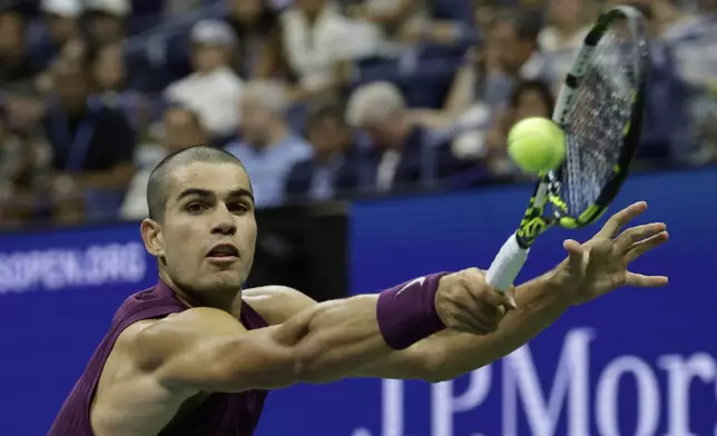 Carlos Alcaraz, of Spain, returns a shot to Reilly Opelka, of the United States, during the first round of the U.S. Open tennis championships, Monday, Aug. 25, 2025, in New York. (AP Photo/Adam Hunger)