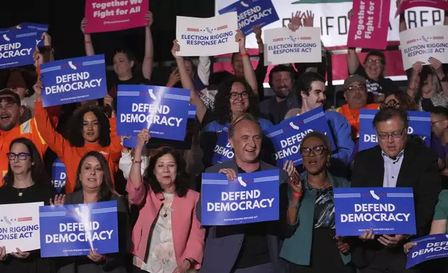 People await a news conference with California Gov. Gavin Newsom Thursday, Aug. 14, 2025, in Los Angeles. (AP Photo/Marcio Jose Sanchez)
