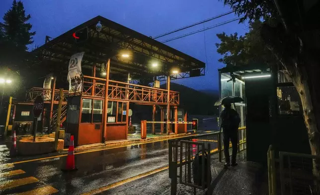 A man stands at the entrance of El Teniente copper mine, operated by Codelco, where a collapse killed one worker and trapped five others underground, leading to a suspension of operations in Rancagua Chile, Friday, Aug. 1, 2025. (AP Photo/Esteban Felix)