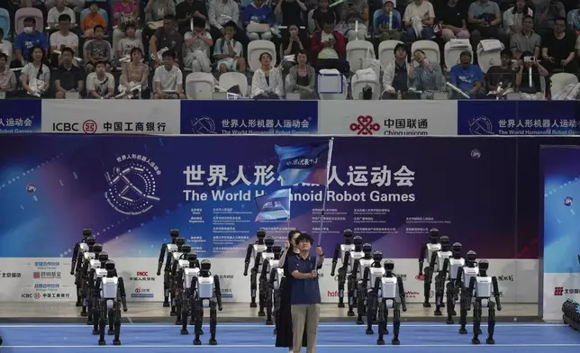 Robots march in for the opening ceremony of The World Humanoid Robot Games held in Beijing, China, Thursday, Aug. 14, 2025. (AP Photo/Ng Han Guan)