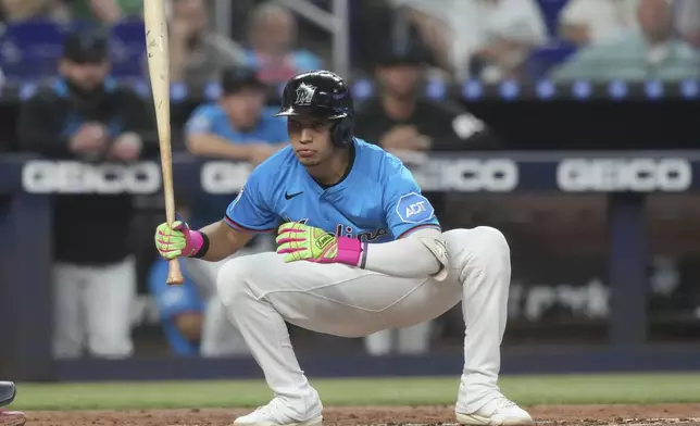 Miami Marlins' Javier Sanoja crouches down to avoid a pitch during the third inning of a baseball game against the Toronto Blue Jays, Sunday, Aug. 24, 2025, in Miami. (AP Photo/Marta Lavandier)