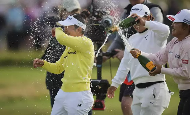 Miyu Yamashita, left, of Japan celebrates after winning the Women's British Open golf championship, at Royal Porthcawl Golf Club in Porthcawl, Wales, Sunday, Aug. 3, 2025. (AP Photo/Kin Cheung)