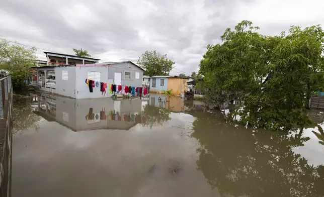 Water surrounds a house in Guayama, Puerto Rico, as Hurricane Erin brings rains to the island, Sunday, Aug. 17, 2025. (AP Photo/Alejandro Granadillo)