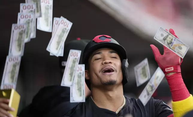 Cincinnati Reds' Noelvi Marte celebrates in the dugout after hitting a solo home run during the first inning of a baseball game against the St. Louis Cardinals Friday, Aug. 29, 2025, in Cincinnati. (AP Photo/Carolyn Kaster)