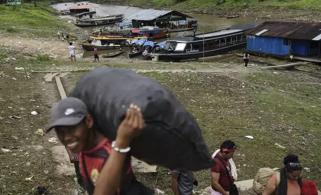 Residents of Santa Rosa, a Peruvian island on the Amazon River, load goods in Leticia, Colombia, Sunday, Aug. 17, 2025. (AP Photo/Ivan Valencia)