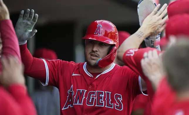 Los Angeles Angels designated hitter Mike Trout celebrates in the dugout after scoring off a double hit by Taylor Ward during the first inning of a baseball game against the Detroit Tigers, Saturday, Aug. 9, 2025, in Detroit. (AP Photo/Ryan Sun)