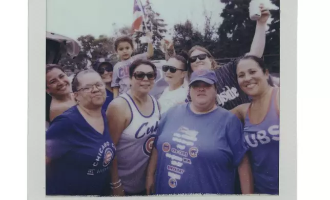 Jeremiah Avila, 4, top, holds a Puerto Rican flag as friends and family tailgate before a Chicago Cubs versus Chicago White Sox Crosstown Classic series baseball game Saturday, July 26, 2025, in Chicago. (AP Photo/Erin Hooley)