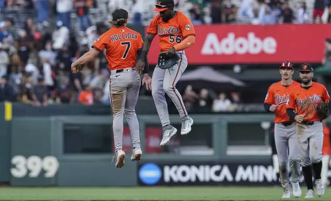 Baltimore Orioles second baseman Jackson Holliday (7) and left fielder Daniel Johnson (56) celebrate after the team's victory over the San Francisco Giants in a baseball game Saturday, Aug. 30, 2025, in San Francisco. (AP Photo/Godofredo A. Vásquez)