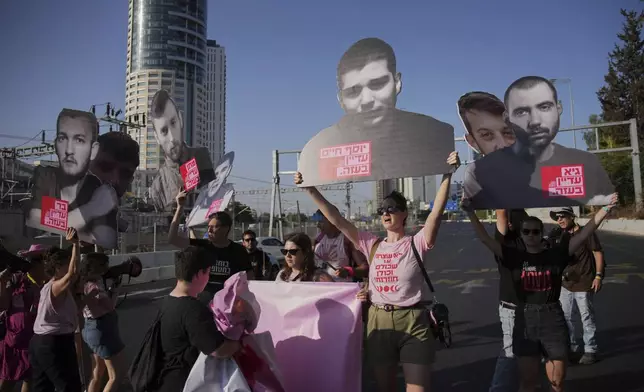 Demonstrators block a road during a protest demanding the immediate release of hostages held by Hamas and calling for the Israeli government to reverse its decision to take over Gaza City and other areas in the Gaza Strip, in Tel Aviv, Israel, Tuesday, Aug. 19, 2025. (AP Photo/Ohad Zwigenberg)
