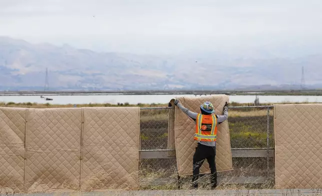 Crew members install sound blankets to protect wildlife at the Pond A2W site of the South Bay Salt Pond Restoration Project, Thursday, July 24, 2025, in Mountain View, Calif. (AP Photo/Godofredo A. Vásquez)
