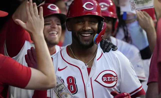 Cincinnati Reds' Miguel Andujar celebrates in the dugout after hitting a grand slam home run during the seventh inning of a baseball game against the Philadelphia Phillies Wednesday, Aug. 13, 2025, in Cincinnati. (AP Photo/Carolyn Kaster)