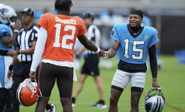 Cleveland Browns quarterback Shedeur Sanders greets Carolina Panthers wide receiver Jimmy Horn Jr. during an NFL football dual training camp Wednesday, Aug. 6, 2025, in Charlotte, N.C. (AP Photo/Chris Carlson)