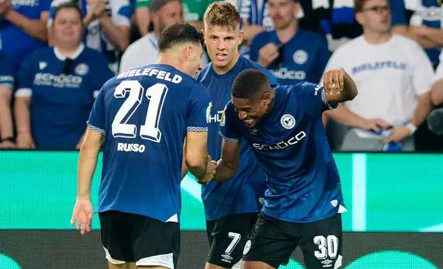 Bielefeld's Isaiah Young celebrates scoring with Stefano Russo, left, during the DFB Cup 1st round soccer match between Arminia Bielefeld and Werder Bremen at Schüco Arena, Bielefeld, Germany, Friday Aug. 15, 2025. (Bernd Thissen/dpa via AP)