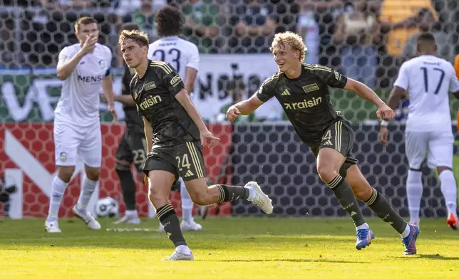 Berlin's Robert Skov, left, celebrates scoring with Leopold Querfeld during the DFB Cup first round between FC Gütersloh and 1. FC Union Berlin in Gütersloh, Germany, Friday Aug. 15, 2025. (David Inderlied/dpa via AP)