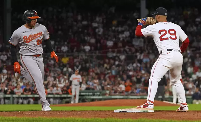 Baltimore Orioles' Samuel Basallo, left, drives home Jeremiah Jackson, breaking a 3-3 tie, as Boston Red Sox first baseman Abraham Toro (29) makes the force out in the eleventh inning of a baseball game at Fenway Park, Tuesday, Aug. 19, 2025, in Boston. (AP Photo/Charles Krupa)