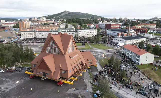 On a specially designed trolley with 224 wheels, Kiruna Church is moved for relocation at a speed of half a kilometer per hour, in Kiruna, Sweden, Tuesday Aug. 19, 2025. (Fredrik Sandberg/TT News Agency via AP)