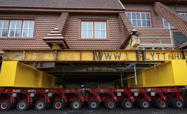 Beams placed on an wheeled structure support the Kiruna Church, a Sami style wooden Swedish Lutheran church, called Kiruna Kyrka in Swedish, in Kiruna, Sweden, Monday, Aug. 18, 2025, a day before it will be moved along a 5-kilometer (3-mile) route east to a new city center as part of the town's relocation.(AP Photo/Malin Haarala)