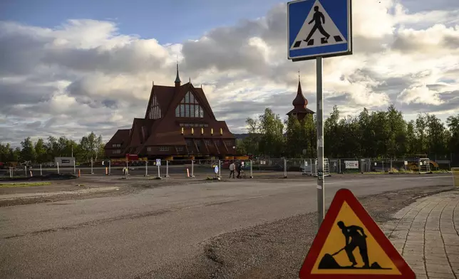 Construction signs are placed outside the Kiruna Church, a Sami style wooden Swedish Lutheran church, called Kiruna Kyrka in Swedish, in Kiruna, Sweden, Saturday, Aug. 16, 2025, a day before it will be moved along a 5-kilometer (3-mile) route east to a new city center as part of the town's relocation.(AP Photo/Malin Haarala)
