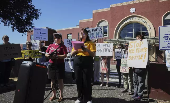 Protesters from the La Resistencia immigrant rights organization speak during a news conference outside of Boeing Field airport in King County, Tuesday, July 15, 2025, in Seattle. (AP Photo/Ryan Sun)
