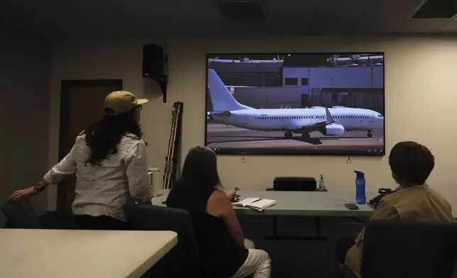 Immigrant rights advocates monitor a webcam available to the public showing a U.S. Immigration and Customs Enforcement flight departing from King County International Airport-Boeing Field, Tuesday, Aug. 19, 2025, in Seattle. (AP Photo/Lindsey Wasson)