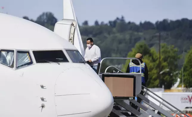 A detainee boards a U.S. Immigration and Customs Enforcement flight departing from King County International Airport-Boeing Field, Tuesday, Aug. 19, 2025, in Seattle. (AP Photo/Lindsey Wasson)
