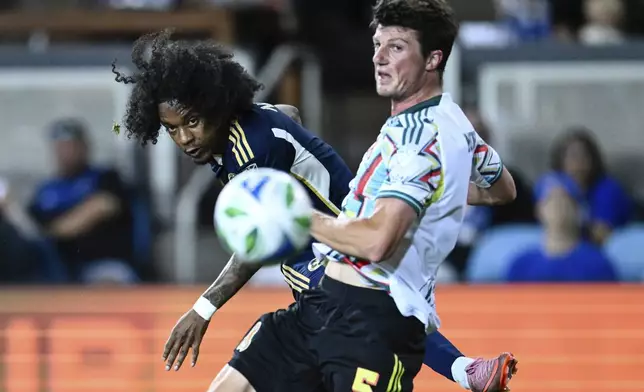 Vancouver Whitecaps forward Jayden Nelson, left, watches his shot against San Jose Earthquakes defender Daniel Munie during the second half of an MLS soccer match Saturday, Aug. 9, 2025, in San Jose, Calif. (AP Photo/Thien-An Truong)