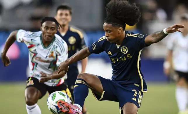 Vancouver Whitecaps forward Jayden Nelson, right, controls the ball against San Jose Earthquakes defender DeJuan Jones, ;eft. during the first half of an MLS soccer match Saturday, Aug. 9, 2025, in San Jose, Calif. (AP Photo/Thien-An Truong)