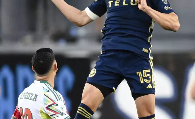 Vancouver Whitecaps defender Bjørn Inge Utvik (15) heads the ball over San Jose Earthquakes midfielder Cristian Espinoza, left, during the first half of an MLS soccer match Saturday, Aug. 9, 2025, in San Jose, Calif. (AP Photo/Thien-An Truong)