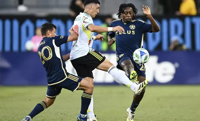 Vancouver Whitecaps midfielder Jean-Claude Ngando, right, fights for the ball against San Jose Earthquakes midfielder Cristian Espinoza, center, during the first half of an MLS soccer match Saturday, Aug. 9, 2025, in San Jose, Calif. (AP Photo/Thien-An Truong)