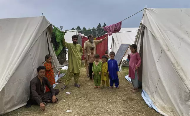 Internally displaced people, who fled their homes after security forces launched a targeted operation against militants, stand at a camp set up in a sports complex at Khar, in the Bajaur district of Khyber Pakhtunkhwa province bordering Afghanistan, Thursday, Aug. 14, 2025. (AP Photo/Qyass Khan)
