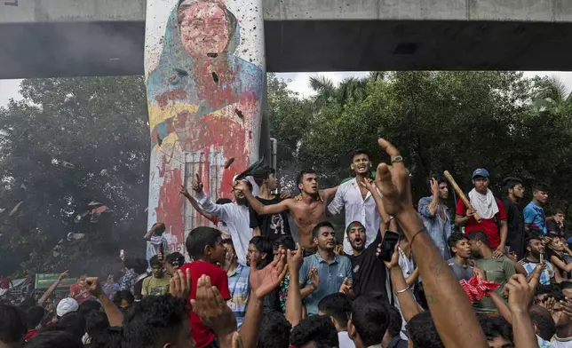 FILE- Protesters celebrate beside a defaced portrait of Prime Minister Sheikh Hasina after news of her resignation, in Dhaka, Bangladesh, Aug. 5, 2024. (AP Photo/Fatima Tuj Johora, File)