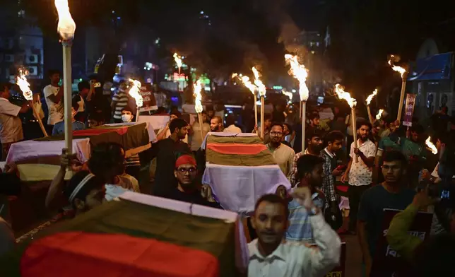 In this July 16, 2025 photo, activists carry symbolic coffins and torches during a procession to mark the day of a student-led protest one year ago, in Dhaka, Bangladesh. (AP Photo/Mahmud Hossain Opu)