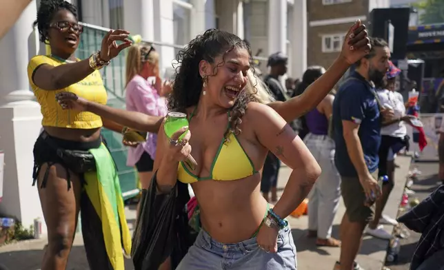 People sing and dance to celebrate Notting Hill Carnival in London, Monday, Aug. 25, 2025, Europe's biggest street party and one of the largest carnivals in the world.(AP Photo/Alberto Pezzali)