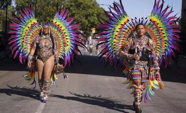 Costumed revellers arrive to take part in the parade during the Notting Hill Carnival in London, Monday, Aug. 25, 2025, Europe's biggest street party and one of the largest carnivals in the world.(AP Photo/Alberto Pezzali)