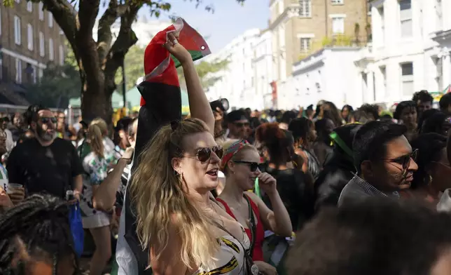 People sing and dance to celebrate Notting Hill Carnival in London, Monday, Aug. 25, 2025, Europe's biggest street party and one of the largest carnivals in the world.(AP Photo/Alberto Pezzali)