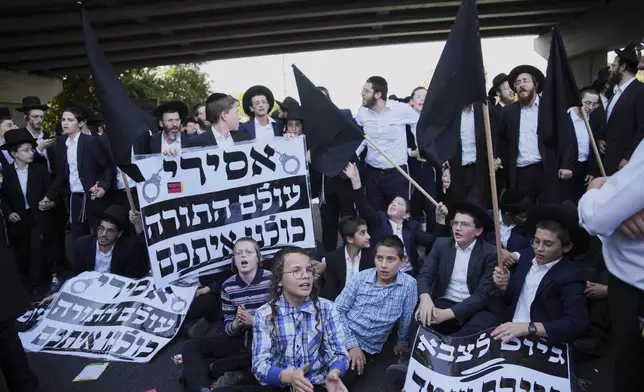 Ultra-Orthodox Jews block a highway during a protest against army recruitment, in Bnei Brak, Israel, Tuesday, Aug. 19, 2025. (AP Photo/Ohad Zwigenberg)