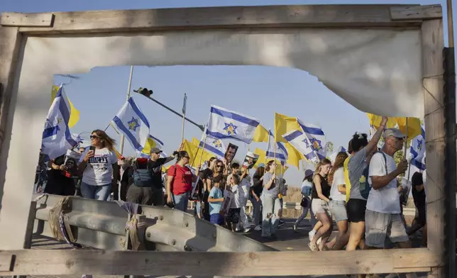 Relatives and supporters of hostages held by Hamas take part in a protest demanding their immediate release and calling for the end of the war in the Gaza Strip as they march on a road near the Israeli-Gaza border, in southern Israel, Wednesday, Aug. 20, 2025. (AP Photo/Maya Levin)