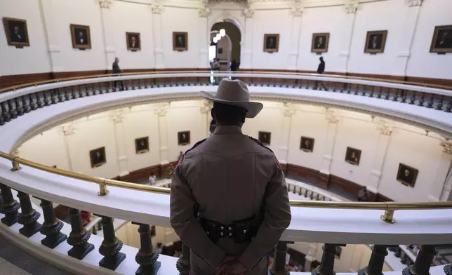 A Texas trooper watches over protesters gathered outside the House Chamber at the Texas Capitol as lawmakers debate a redrawn U.S. congressional map in Texas during a special, Wednesday, Aug. 20, 2025, in Austin, Texas. (AP Photo/Eric Gay)
