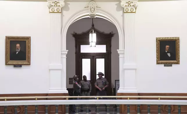 Texas state troopers post outside of the House Chamber where Democratic Texas Rep. Nicole Collier refuses to leave due to a required law enforcement escort, Tuesday, Aug. 19, 2025, in Austin, Texas. (AP Photo/Eric Gay)