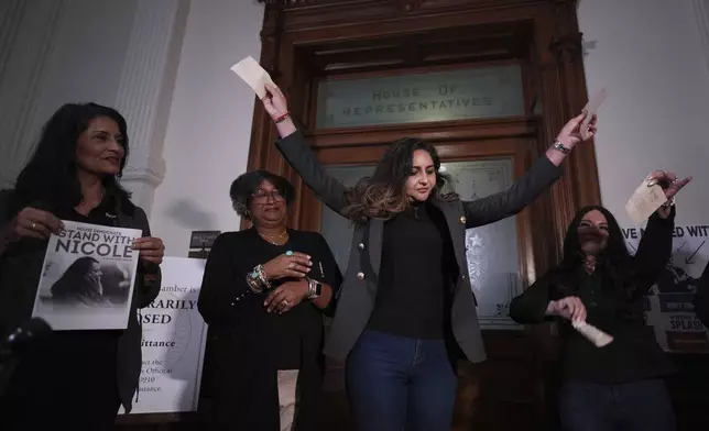 Democratic Texas state Rep. Mihaela Plesa, center, and Rep. Cassandra Garcia Hernandez, right, tear up their 'permission slips' outside of the House Chamber as they plan to join fellow Rep. Nicole Collier who refuses to leave due to a required law enforcement escort, Tuesday, Aug. 19, 2025, in Austin, Texas. (AP Photo/Eric Gay)