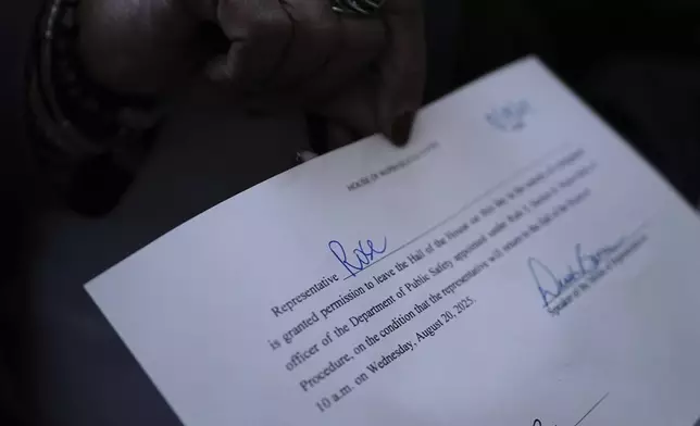 Texas state Rep. Toni Rose shows her permission slip to leave the House Chamber, Monday, Aug. 18, 2025, in Austin, Texas. (AP Photo/Eric Gay)